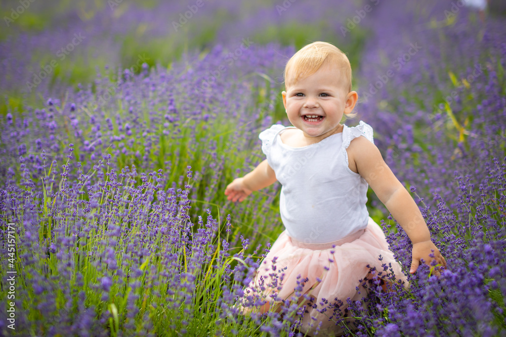 Smiling baby girl in pink dress in a lavender field in Czech republic