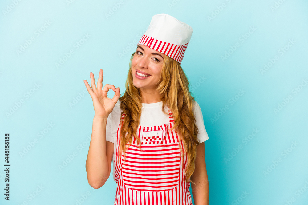 Caucasian ice cream maker woman isolated on blue background cheerful and confident showing ok gesture. Caucasian ice cream maker woman isolated on blue background cheerful and confident showing ok gesture.