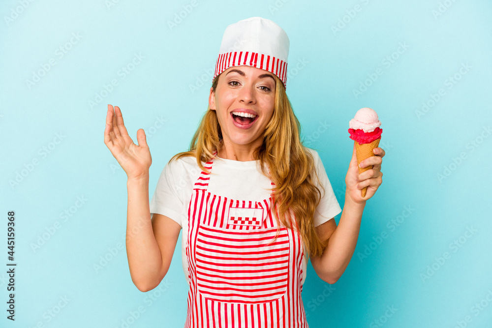 Caucasian ice cream maker woman holding an ice cream isolated on blue background receiving a pleasant surprise, excited and raising hands. Caucasian ice cream maker woman holding an ice cream isolated on blue background receiving a pleasant surprise, excited and raising hands.