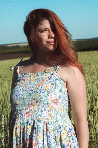 
A pregnant girl in a field with wheat looks natural and beautiful