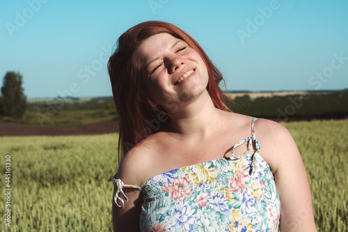 
A pregnant girl in a field with wheat looks natural and beautiful