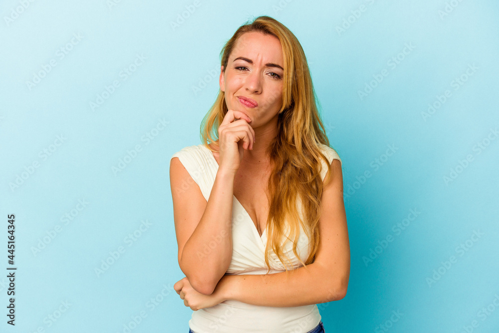Caucasian woman isolated on blue background thinking and looking up, being reflective, contemplating, having a fantasy. Caucasian woman isolated on blue background thinking and looking up, being reflective, contemplating, having a fantasy.