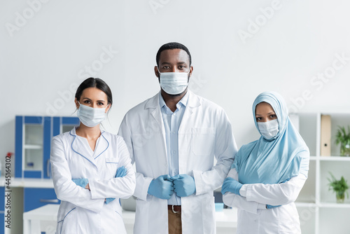 Multiethnic doctors in medical masks standing in hospital