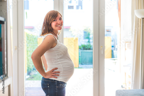 Happy pregnant mother in blue jeans is hugging her tummy, close up Free Download Happy pregnant mother in blue jeans is hugging her tummy, close up - GFXLoad