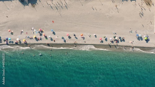 Vista verticale di una spiaggia con ombrelloni e sabbia photo