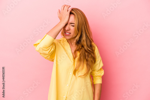 Caucasian blonde woman isolated on pink background forgetting something, slapping forehead with palm and closing eyes.