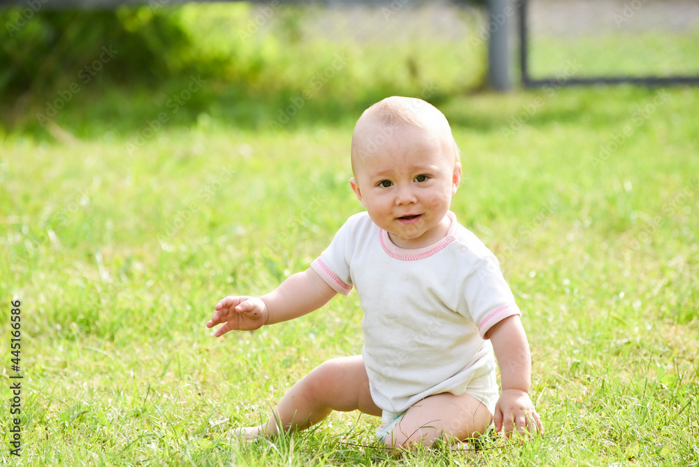 Smiling one year boy sitting in grass outdoors,summer photo Smiling one year boy sitting in grass outdoors,summer photo