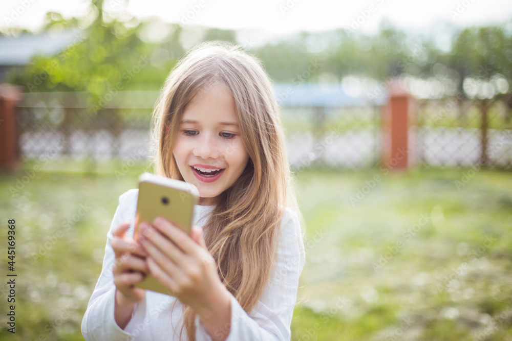 beautiful girl in a white blouse with smartphone in nature in sunlight beautiful girl in a white blouse with smartphone in nature in sunlight