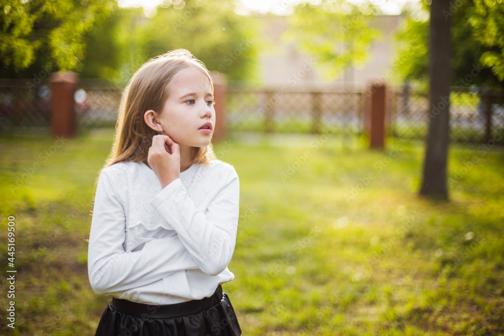 beautiful girl in a white blouse thinking about something in nature in sunlight beautiful girl in a white blouse thinking about something in nature in sunlight