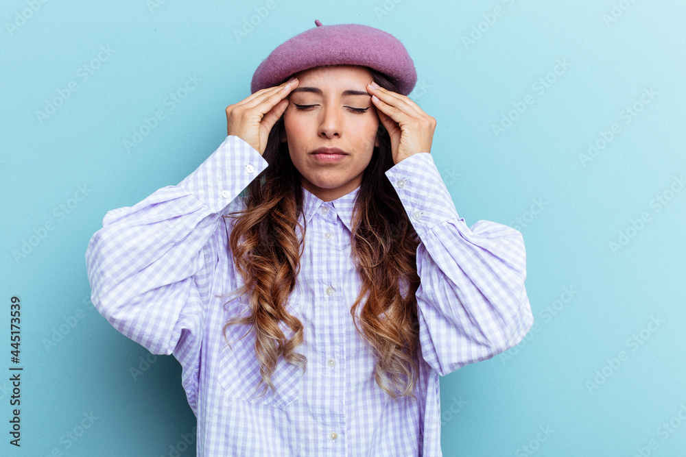 Young mexican woman isolated on blue background touching temples and having headache. Young mexican woman isolated on blue background touching temples and having headache.