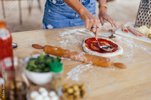 Adult woman, making sure his pizza is tasty and delicious. photo