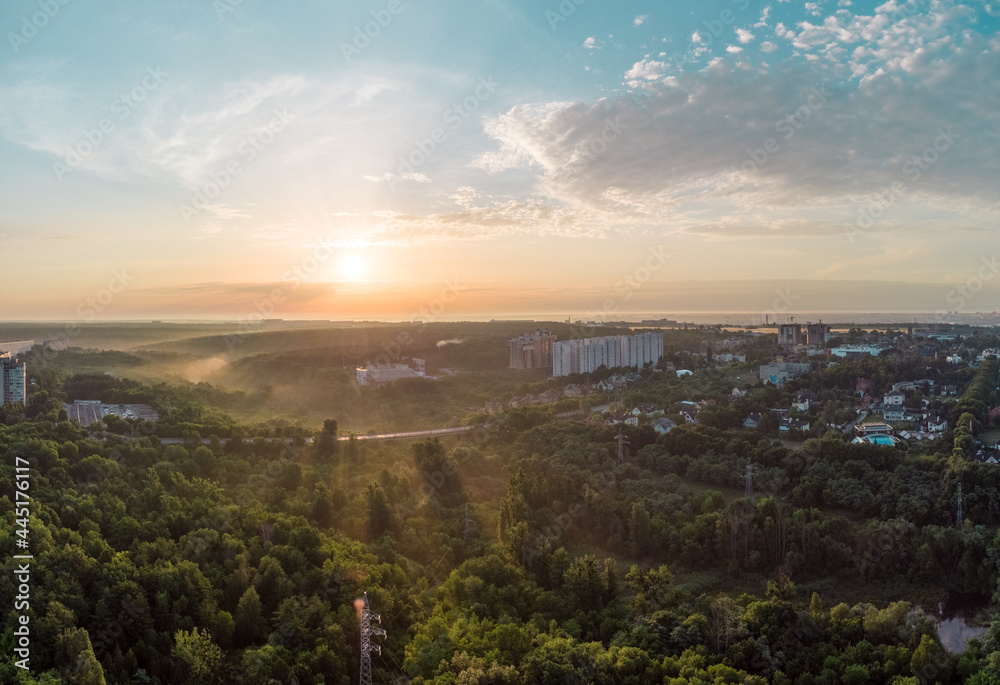 Aerial sunrise morning sky panorama. Multistory buildings and greenery with fog at dawn in nice pastel light. View on Sokilnyky with Derevianka st bridge across Sarzhyn Yar in Kharkiv city.