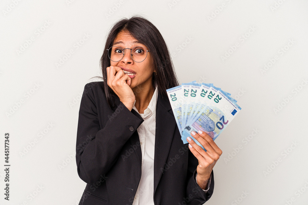 Young business latin woman holding bills isolated on white background biting fingernails, nervous and very anxious. Young business latin woman holding bills isolated on white background biting fingernails, nervous and very anxious.