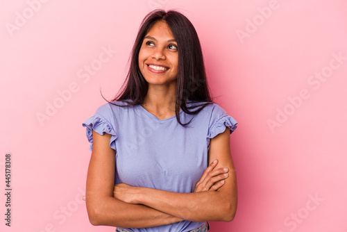 Papier peint Young latin woman isolated on pink background smiling confident with crossed arms