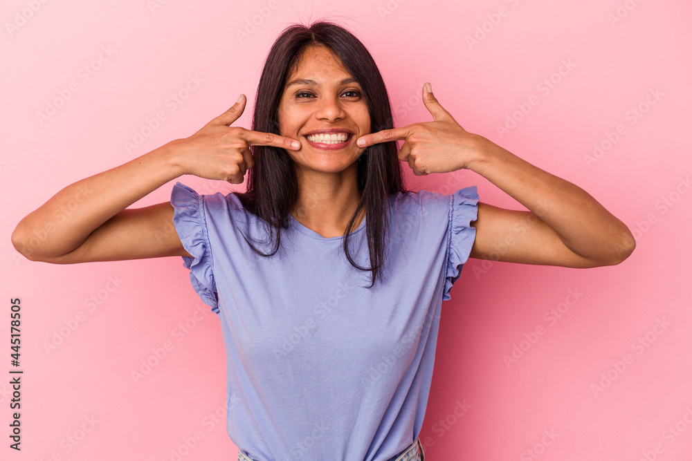 Young latin woman isolated on pink background smiles, pointing fingers at mouth. Young latin woman isolated on pink background smiles, pointing fingers at mouth.