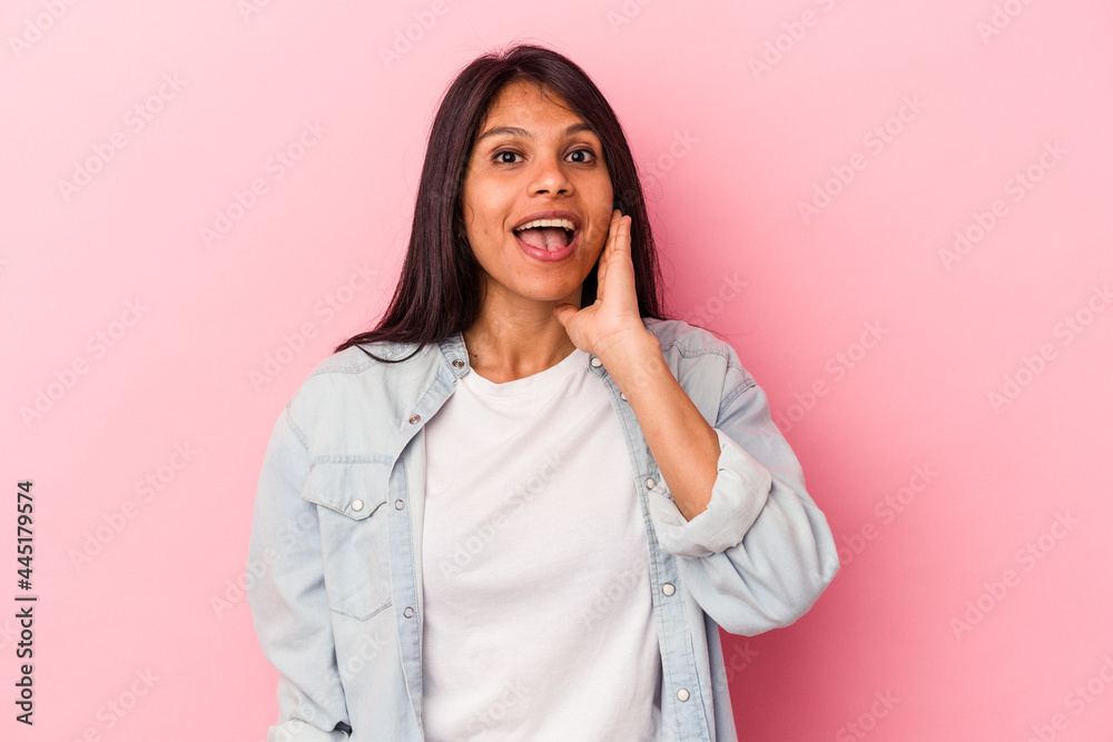 Young latin woman isolated on pink background shouts loud, keeps eyes opened and hands tense. Young latin woman isolated on pink background shouts loud, keeps eyes opened and hands tense.