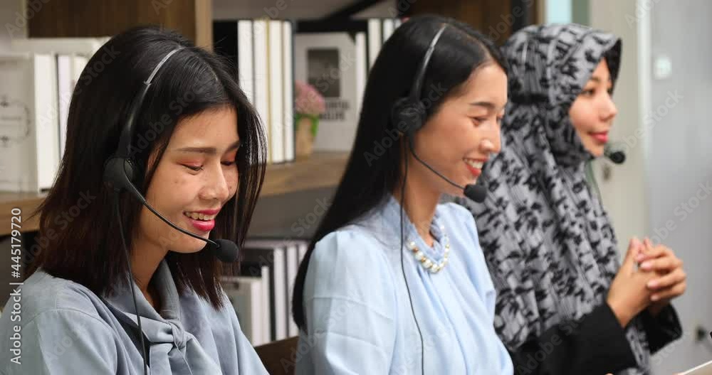 Asian woman operator and team working with headsets and desktop computer at telemarketing customer service Asian woman operator and team working with headsets and desktop computer at telemarketing customer service