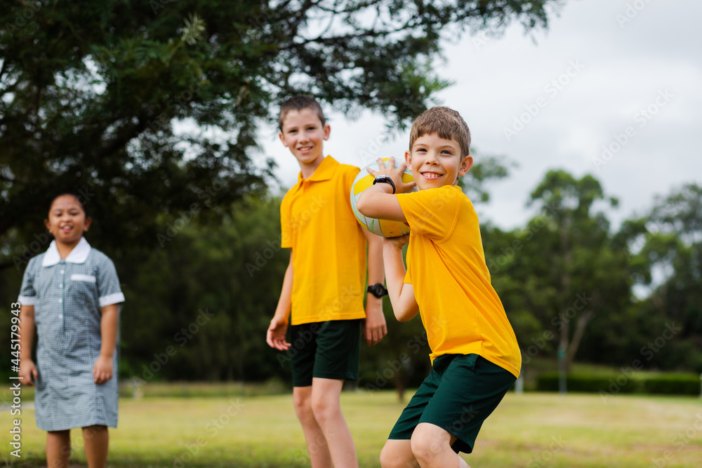 Happy smiling school boy throwing ball outside Happy smiling school boy throwing ball outside