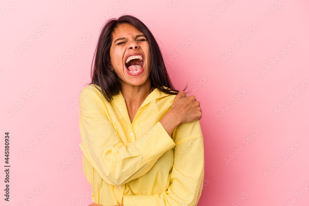 Young latin woman isolated on pink background having a shoulder pain. Young latin woman isolated on pink background having a shoulder pain.