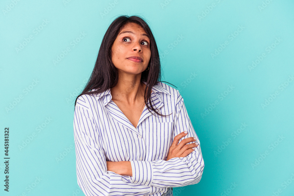 Obraz premium Young latin woman isolated on blue background dreaming of achieving goals and purposes