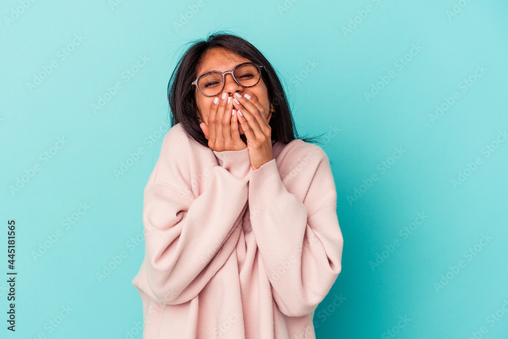 Young latin woman isolated on blue background laughing about something, covering mouth with hands. Young latin woman isolated on blue background laughing about something, covering mouth with hands.