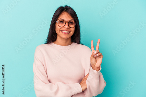 Young latin woman isolated on blue background showing number two with fingers.