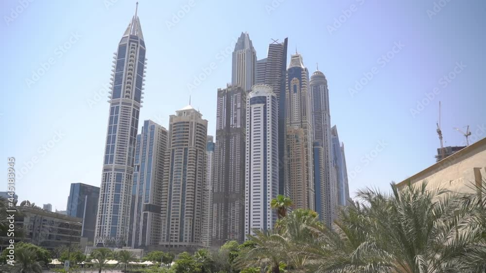 view of skyscrapers and palm trees dubai marina in uae view of skyscrapers and palm trees dubai marina in uae