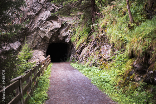 Walkway inside the tunnel in the rock. Tourist hiking trail in the mountains. Austria, South Tyrol.