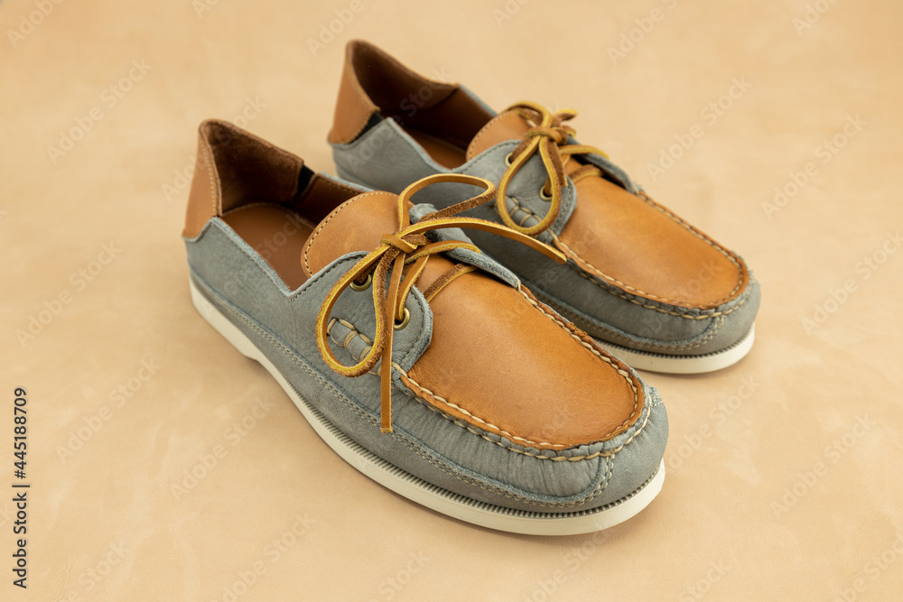 Naklejka premium Classic men's leather boat shoes. These laced loafers are the traditional fashion accessory for preppy boating male.
