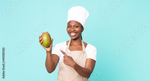 black african american adult chef woman hwith a mango photo