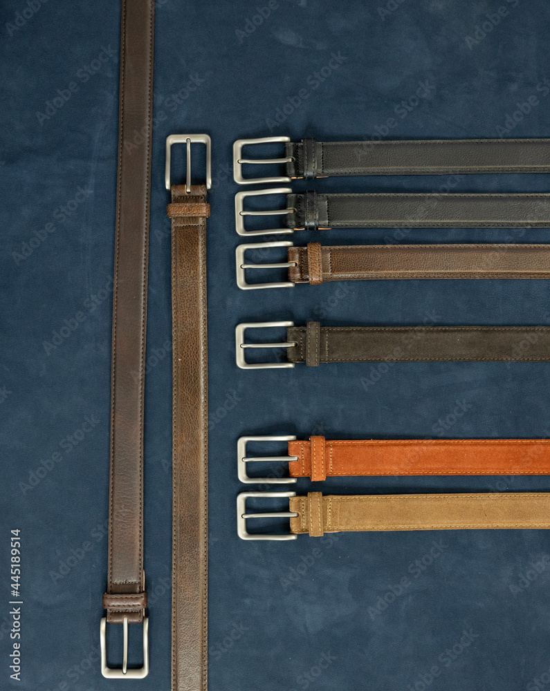Leather belts for men on a dark background. These formal belts are made from suede and cowhide leather.