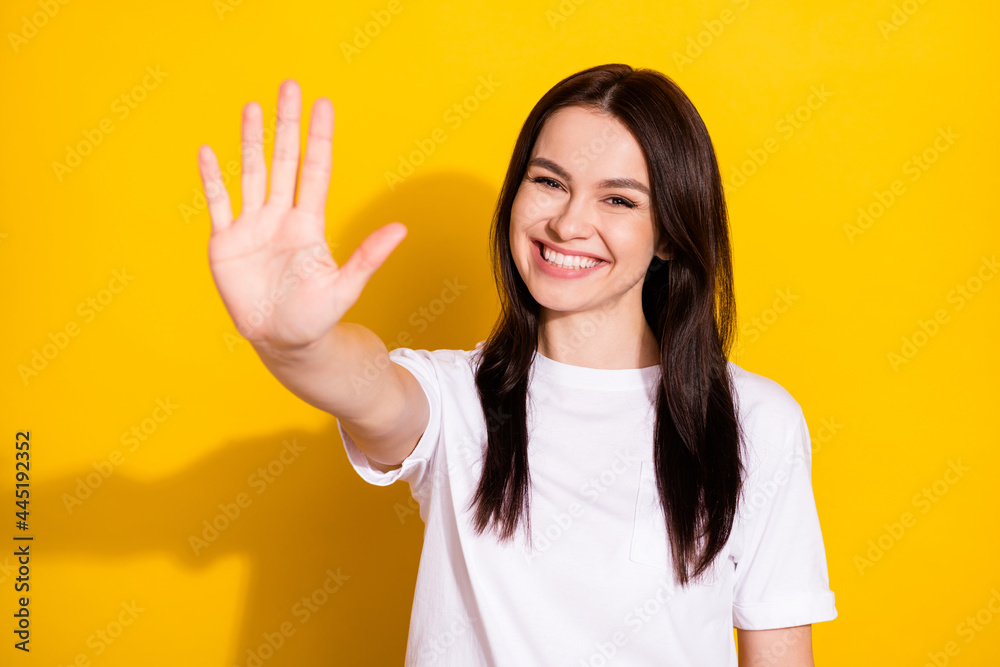Photo of cheerful positive young woman hold hands give you high five isolated on yellow color background Photo of cheerful positive young woman hold hands give you high five isolated on yellow color background