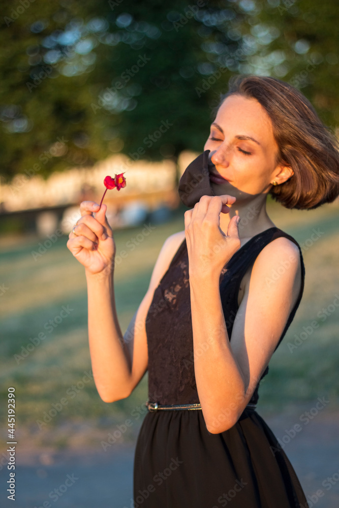 person taking off a medicine mask from face. Girl smelling flowers and easy breathing. Covid-19 free concept person taking off a medicine mask from face. Girl smelling flowers and easy breathing. Covid-19 free concept