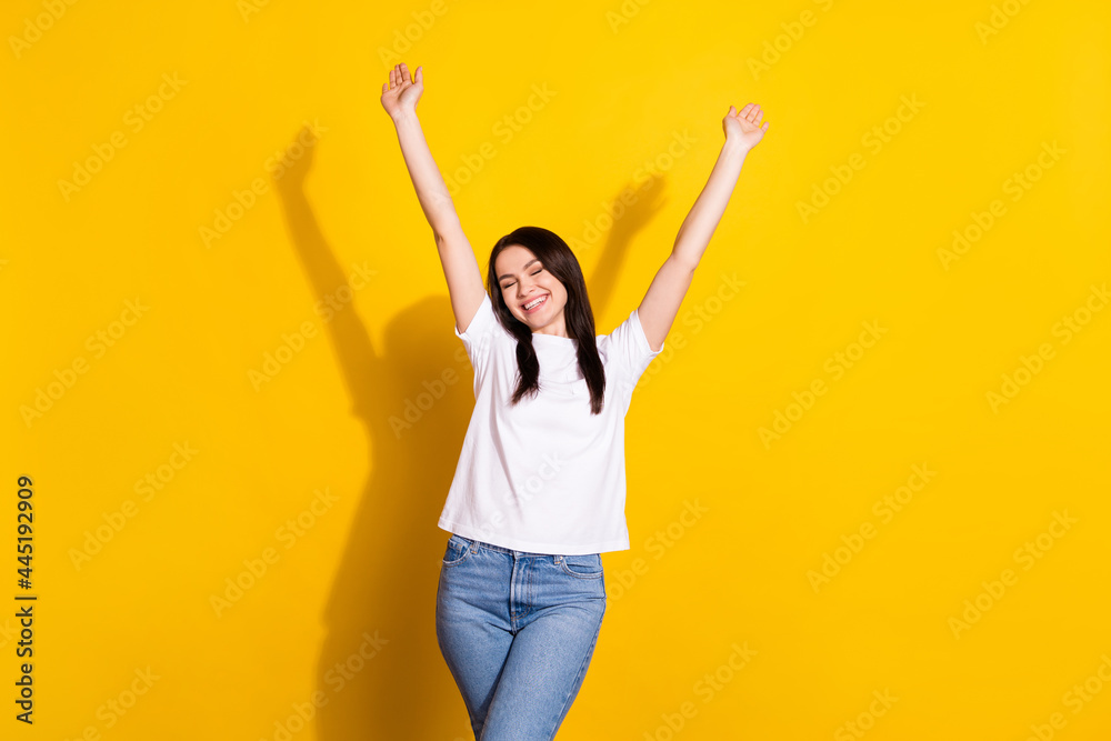 Photo of happy nice young pretty woman raise hands enjoy weekend isolated on shine yellow color background Photo of happy nice young pretty woman raise hands enjoy weekend isolated on shine yellow color background