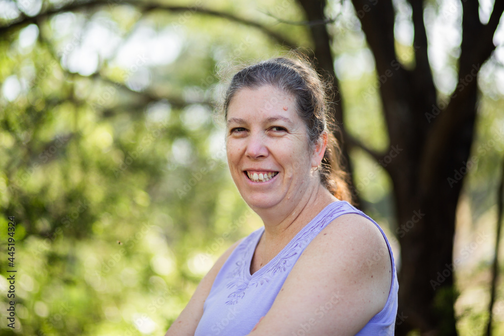 headshot of happy middle aged woman standing outside with copy space headshot of happy middle aged woman standing outside with copy space
