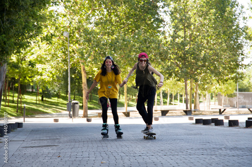 Fotografie girls skating in the street shaking hands