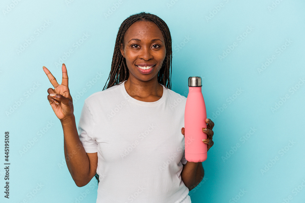Young african american woman holding canteen isolated on blue background showing number two with fingers.