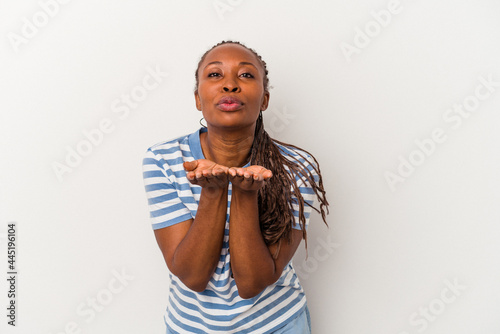 Young african american woman isolated on white background folding lips and holding palms to send air kiss.