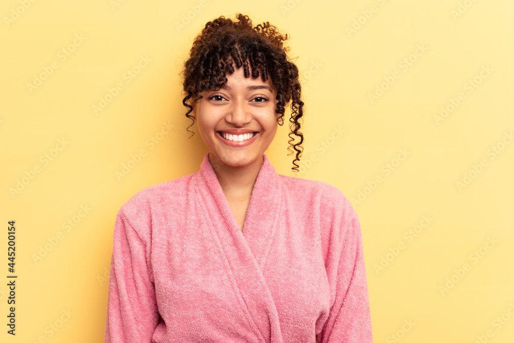 Young mixed race woman wearing a pink bathrobe isolated on pink background happy, smiling and cheerful. Young mixed race woman wearing a pink bathrobe isolated on pink background happy, smiling and cheerful.