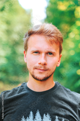 Portrait of a young blonde man with stubble in the park