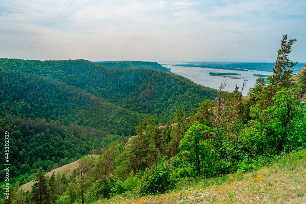 Panorama of mountains with a dense forest and the Volga River on the background, photographed from a height. Nature of Russia