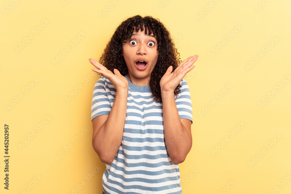 Young mixed race woman isolated on yellow background surprised and shocked. Young mixed race woman isolated on yellow background surprised and shocked.