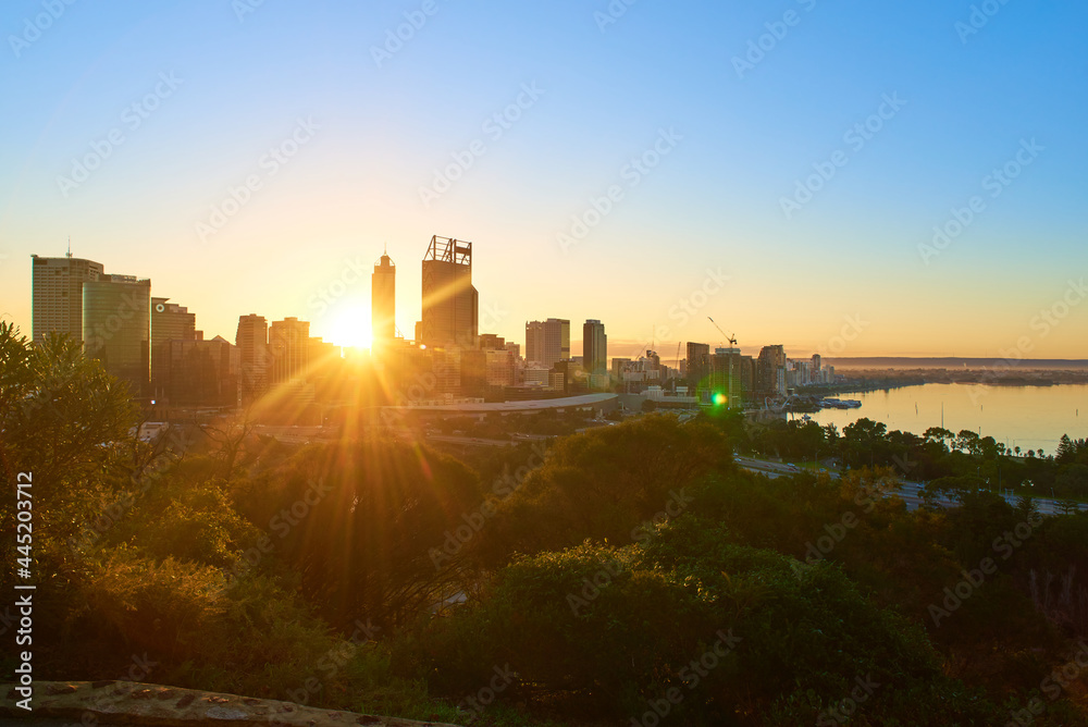 The sun rising above the Perth City skyline as seen from King's Park on a misty morning. The sun rising above the Perth City skyline as seen from King's Park on a misty morning.
