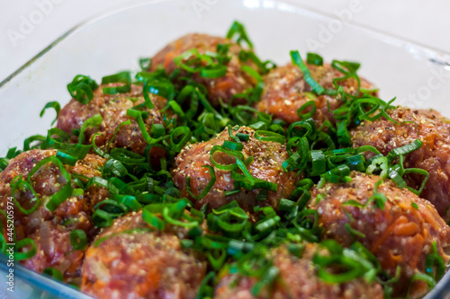 Raw meatballs made from organic meat, vegetables and spices, ready for baking in the oven, are an excellent source of protein.