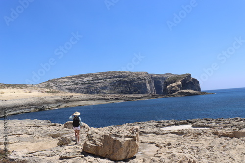 European girl overlooking the blue hole azure window in Malta Gozo beautiful scenery
