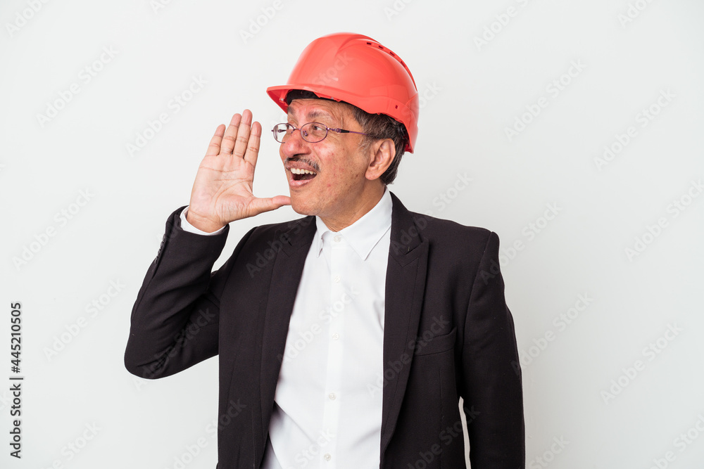Middle aged indian architect man isolated on white background shouting and holding palm near opened mouth. Middle aged indian architect man isolated on white background shouting and holding palm near opened mouth.