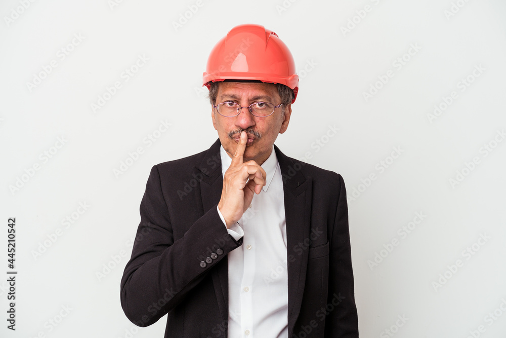 Middle aged indian architect man isolated on white background keeping a secret or asking for silence. Middle aged indian architect man isolated on white background keeping a secret or asking for silence.