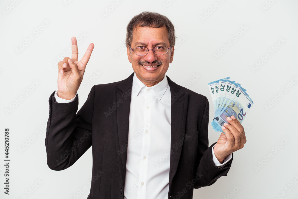 Middle aged indian business man holding bills isolated on white background showing number two with fingers. Middle aged indian business man holding bills isolated on white background showing number two with fingers.