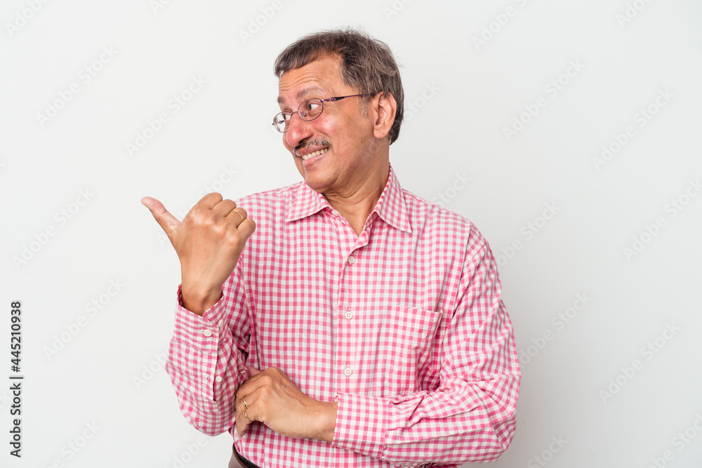 Middle aged indian man isolated on white background points with thumb finger away, laughing and carefree. Middle aged indian man isolated on white background points with thumb finger away, laughing and carefree.