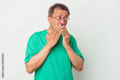 Fototapeta Naklejka Na Ścianę i Meble -  Middle aged indian man isolated on white background thoughtful looking to a copy space covering mouth with hand.